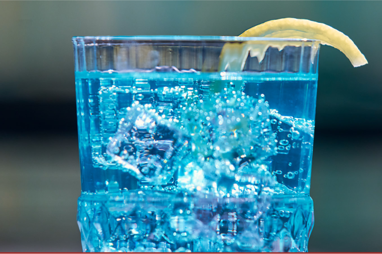 A blue tinted cocktail with a lemon twist
